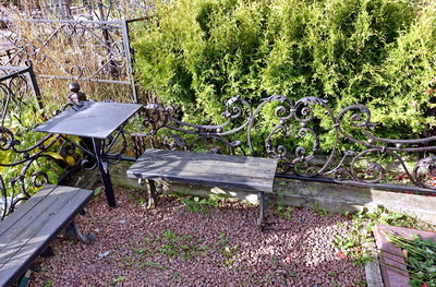 Красивая черная кованая ограда с лавочками и столиком